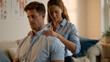 © Tania - Female somatic therapist pressing both palms gently against a seated client's upper back in a softly furnished therapy room, the client breathing deeply with eyes closed, anatomical diagrams of the
