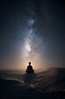 © SB4 GM - Silhouette meditating on sand dunes under starry cosmic night sky with galaxy light