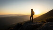 © CrazyJuke - Summit Serenity: A lone hiker, silhouetted against a breathtaking sunset, stands on a rocky peak, gazing out at the vast, layered mountain landscape, embodying solitude and the spirit of adventure.