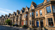 © Pupun - Beautiful Victorian sandstone terraced houses in Edinburgh Scotland featuring elegant bay windows and colorful doors on a sunny residential street