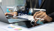 © Father_Studio - Businessman managing ERP software system on tablet and laptop with digital dashboards for enterprise resource planning and business analytics, workflow automation, business intelligence.