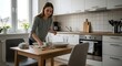 © Narachan Studio - Young Woman Setting the Table in a Bright Modern Kitchen with White Cabinets and Natural Light