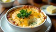 © Vadym - Creamy baked grits with melted cheese and fresh parsley garnish in white bowl. Savory, cheesy comfort food served warm in a rustic setting, perfect for breakfast or side dish.