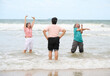 © offsuperphoto - Elderly women exercising on the beach, with gentle waves lapping at their feet. The two women on the sides are stretching