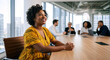 © Vyatcheslav - Smiling woman sitting at conference table. Diverse team meeting in modern office