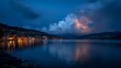 © Plaifah - Serene twilight over calm lake with glowing reflections from city lights under a dramatic stormy sky filled with clouds and hints of lightning in the distance