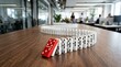 © Mey - A domino chain lies on a wooden table, with two dominoes fallen over. The dominoes are white and red.