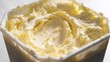 © olga_demina - Tub of soft whipped butter with swirls on white background.