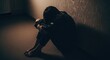 © Bejo Studio - A lonely person sits in a dark corner head bowed in despair.