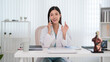 © Pichsakul - Asian female doctor medical professional talking phone call consultation patient discussion office desk white coat modern clinic healthcare telemedicine