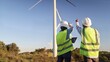 © NJF - Engineers inspecting wind turbine farm, planning renewable energy solutions for a sustainable future, discussing power generation technology outdoors
