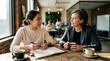 © FENTY - Businesswomen Discussing Strategy Over Coffee at Cafe In Collaborative Atmosphere