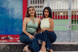 © Mario Vásquez Rioja - Dos jóvenes amigas sonriendo y posando juntas al aire libre celebrando el Día de la Juventud.