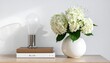 © Ata - Minimalist white vase with blooming hydrangea flowers on wooden shelf.
