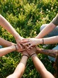 © Artem Zatsepilin - close up of diverse people stacking hands together over green grass background. teamwork, unity and community support concept. friendship and collaboration. corporate team building, youth group poster