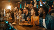 © ArtFocus Studio - Excited diverse group of friends cheering for sports match in a lively sports bar, watching TV, drinking beer and eating pizza, celebrating victory