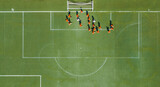 Aerial view of children in orange jerseys running across the soccer field during soccer practice at a sports park in Wuhan, China.
