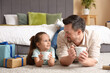 © Pixel-Shot - Father and his daughter drinking tea in bedroom. Father's Day celebration