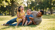 © Jian - Father's Day joy with Latino dad and two laughing children playing in park grass for family celebration greeting card social media poster holiday advertising