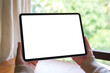 © Farknot Architect - Mockup image of a woman holding digital tablet with blank white desktop screen at home