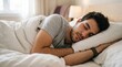 © Karan - Young man sleeping peacefully in bed under white blankets with sleeping comfortable wellness peaceful recovery