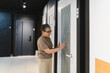 © Serhii - Woman choosing new modern door in showroom