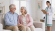 © Jennifer - Senior Couple Consulting with Female Doctor at Home