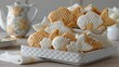 © Megin Design - 白と茶色の鯛焼きが盛られた白いトレイ。ティーポットのある明るい室内での和菓子のティータイム。日本の伝統的なスイーツ