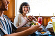 © oneinchpunch - Happy friends enjoying burgers and smoothies at diner - Happy multiracial students meeting in a fast food restaurant to have fun together and celebrate
