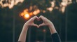 © Jhorna - Hands forming a heart shape with sunset background