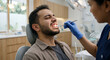 © Jai Izzam - Dentist examining male patient experiencing dental pain in clinic