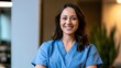 © Thares2020 - A professional woman wearing medical scrubs smiles warmly in a bright indoor setting