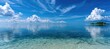 © Emil - Serene turquoise waters meet a vast blue sky with fluffy clouds, reflecting calm