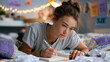 © Tania - Teenage girl lying on her stomach across a patchwork quilt on her bedroom floor, writing intensely in an open journal with a worn pen, fairy lights strung above her desk, motivational cut-outs pinne