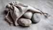 © jimh - Smooth Stones Resting in a Hand-Stitched Linen Pouch on a Textured Surface