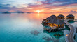 © Wesa - Overwater bungalows at a tropical luxury resort during sunset