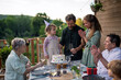 © Halfpoint - Multi generation family grilling outside on patio in summer during garden party