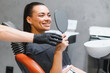 © Serhii - Patient smiling while viewing braces in mirror after dental checkup