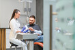 © Serhii - Dentist discussing oral health with male patient in clinic