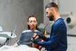 © Serhii - Dentist explaining teeth model to female patient