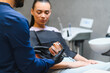 © Serhii - Dentist explaining jaw model to female patient