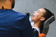 © Serhii - Dentist examining patient's open mouth during checkup