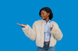 © EDUARDOIVAN - Young black woman presenting product space with thumbs up