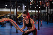 © Niyaz Tavkaev/Stocksy - Determined female athlete exercising with battling ropes