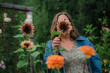 © Louise Forslycke Garbergs/Stocksy - Woman hiding face behind a blooming dark red sunflower