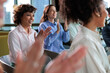 © Jovo Jovanovic/Stocksy - Diverse group of people clapping at a meeting.