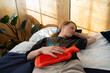 © Danil Nevsky/Stocksy - Person finding period pain relief with hot water bottle