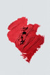 © Tatyana Lavrova/Stocksy - Swatch of textured red lipstick on plain white background.