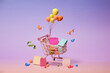© Marc Tran/Stocksy - Whimsical shopping cart with balloons and confetti floating