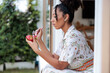 © Jovo Jovanovic/Stocksy - Woman eats dragon fruit by window, peaceful moment.